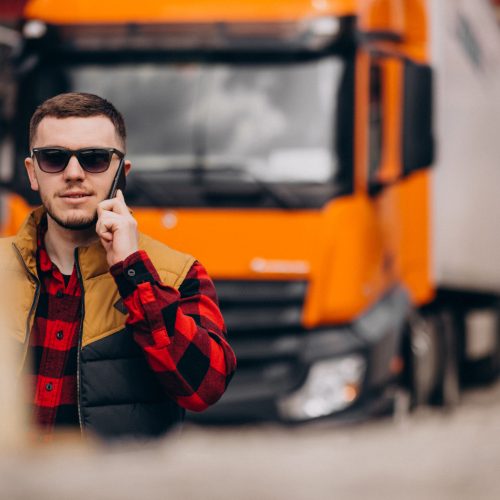 Handsome man truck driver standing by the truck
