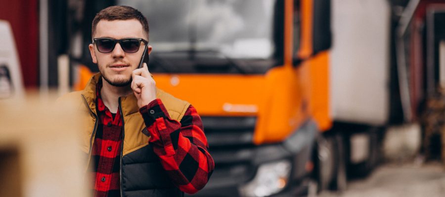 Handsome man truck driver standing by the truck